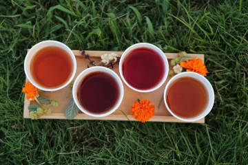 a cup of coffee sitting on top of a grass covered field